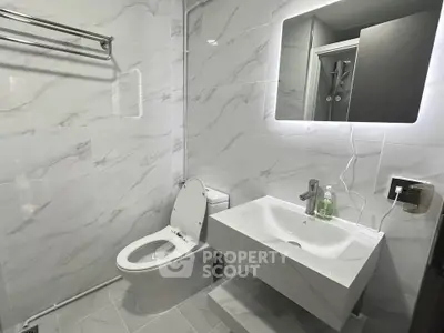 Modern bathroom with sleek white fixtures and elegant marble tiles