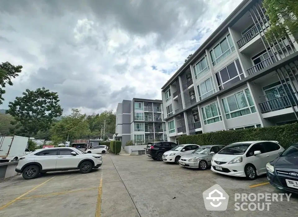 Modern apartment building with parking area and lush greenery