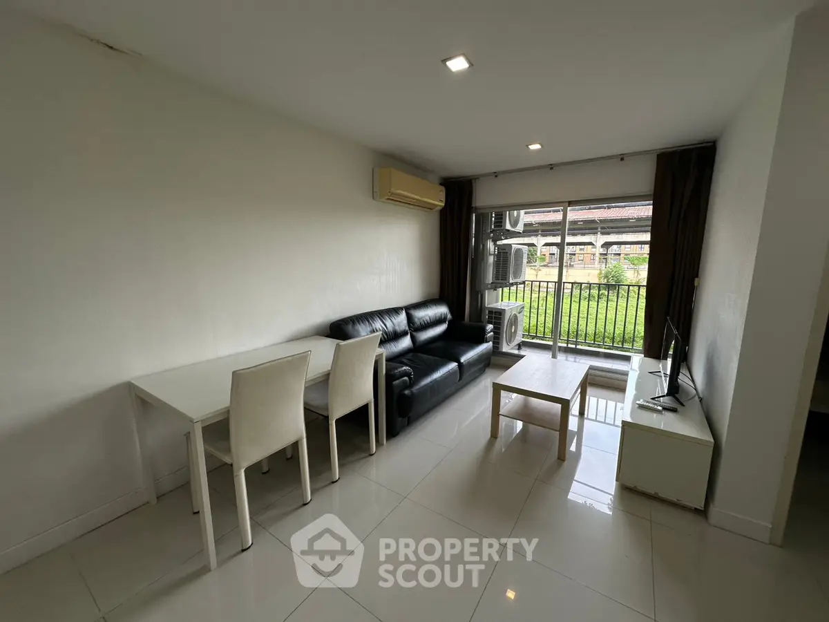 Modern living room with sleek furniture and balcony view in a stylish apartment.