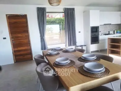 Modern dining area with elegant table setting and stylish kitchen appliances.