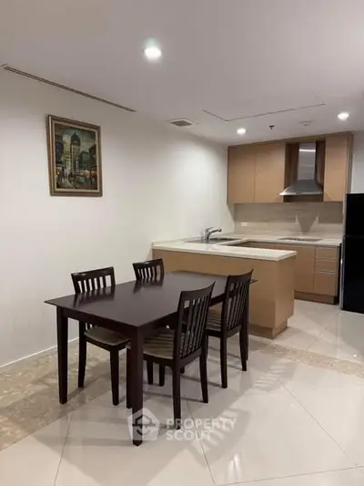 Modern kitchen with dining area featuring sleek cabinetry and elegant dining set.