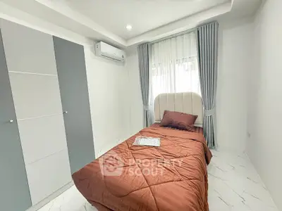Modern bedroom with single bed, air conditioning, and stylish wardrobe