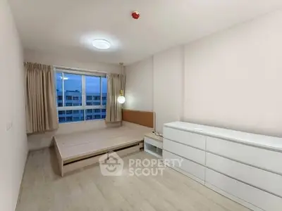 Spacious bedroom with modern minimalist design and large window view.