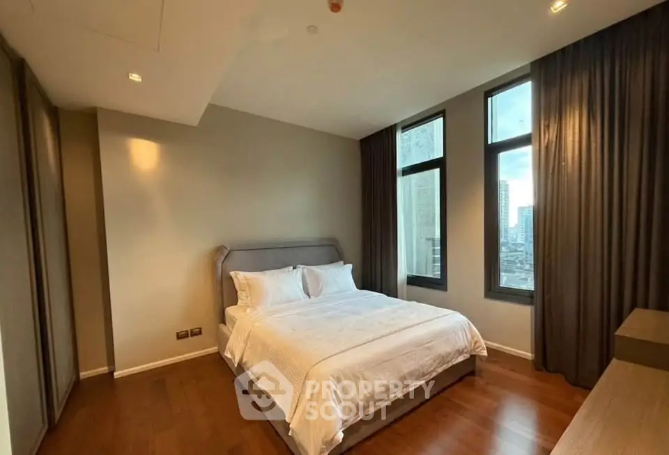 Spacious bedroom with large windows and city view in modern apartment