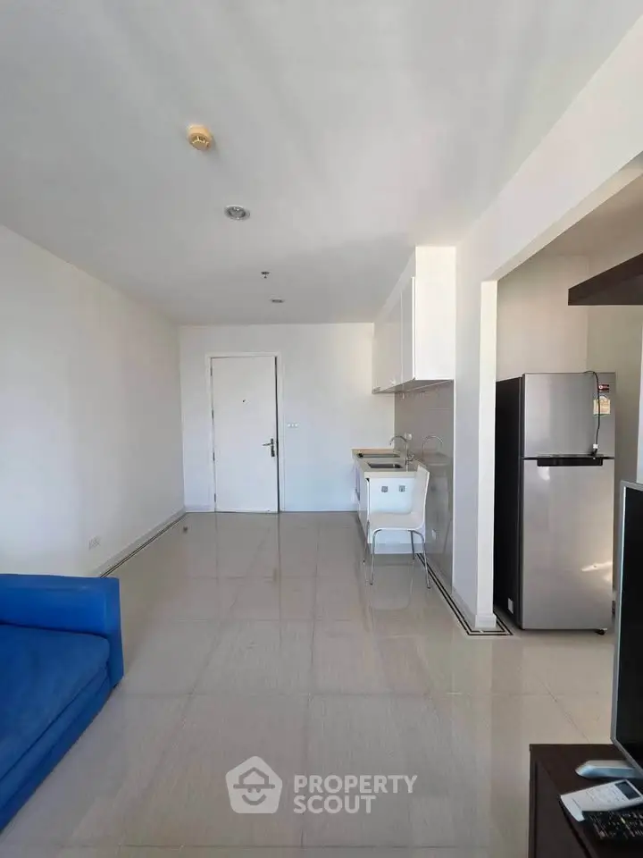 Modern minimalist living room with open kitchen and sleek appliances