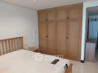 Spacious bedroom with wooden wardrobe and cozy bed in modern apartment