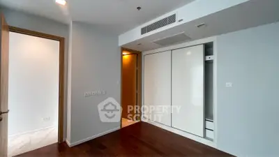 Modern bedroom with sleek built-in wardrobe and wooden flooring