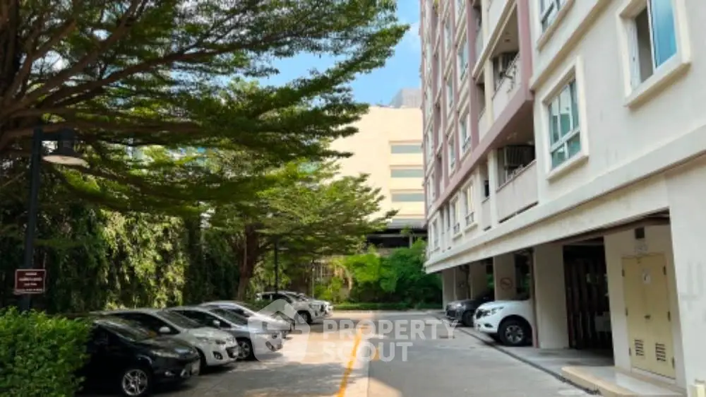 Spacious parking area with lush greenery at modern apartment complex
