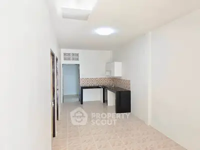 Spacious open-plan kitchen with modern cabinetry and tiled flooring