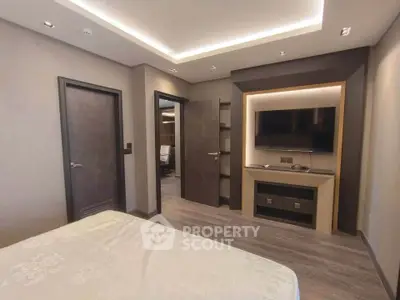 Modern bedroom with sleek design, featuring a wall-mounted TV and ambient lighting.