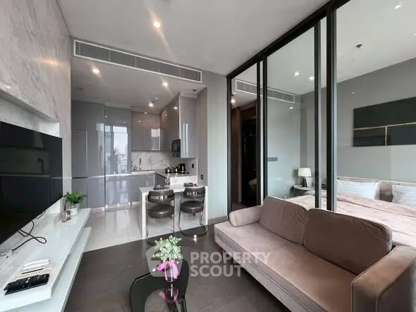 Modern open-plan living room with sleek kitchen and cozy bedroom in luxury apartment.