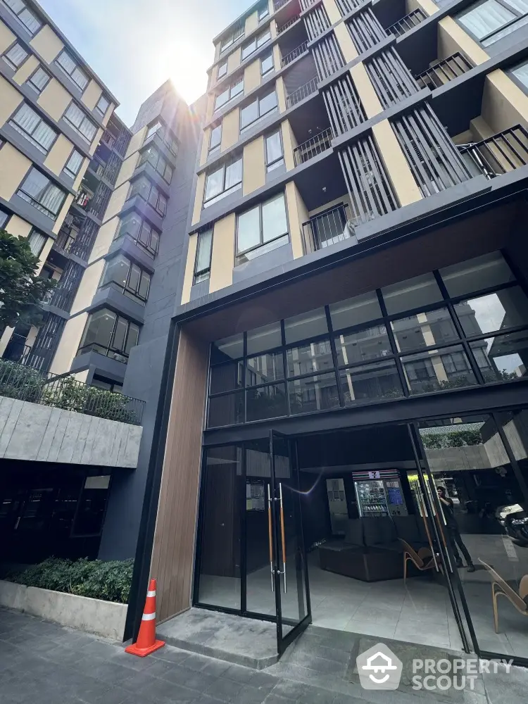 Modern apartment building entrance with sleek design and large glass windows