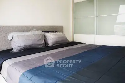 Modern bedroom with stylish bedding and sliding closet doors, perfect for a cozy retreat.