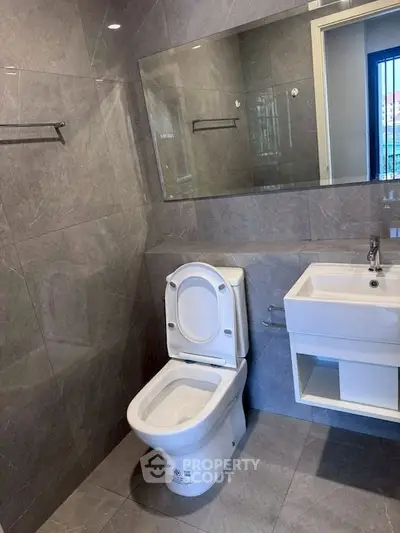 Modern bathroom with sleek gray tiles and contemporary fixtures.