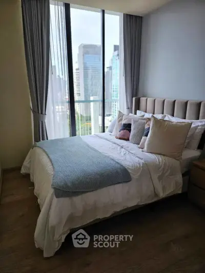 Modern bedroom with city view, featuring large windows and stylish decor in urban apartment.