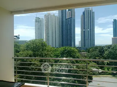 Stunning cityscape view from a modern balcony overlooking lush greenery and skyscrapers.