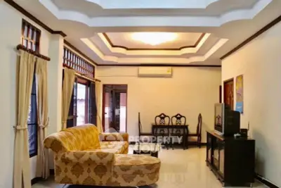 Spacious living room with elegant sofa and dining area, featuring stylish ceiling design.