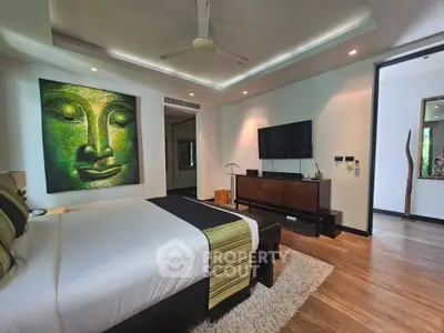Luxurious bedroom with modern decor and large artwork, featuring a sleek TV setup and elegant lighting.