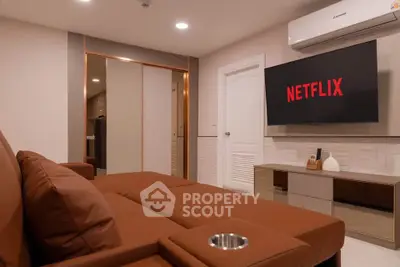 Modern living room with brown sofa, wall-mounted TV, and air conditioning unit.