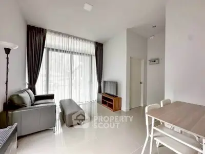 Modern living room with sleek furniture and large windows for natural light.