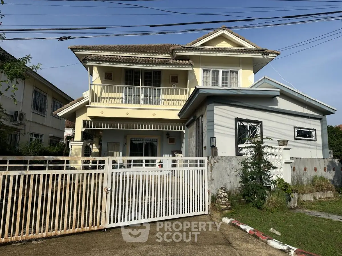 Charming two-story house with gated entrance and lush garden in a serene neighborhood.