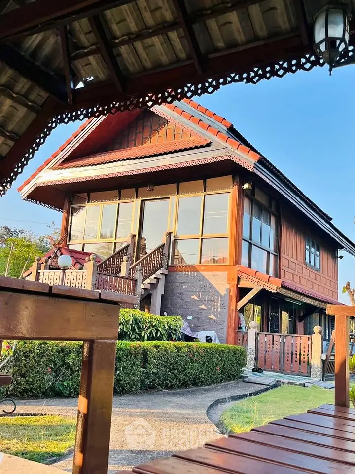 Charming traditional wooden house with lush garden and intricate architectural details.