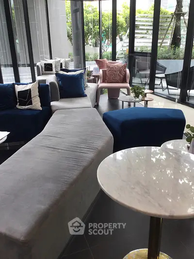 Luxurious modern living room with stylish furniture and large windows overlooking greenery.