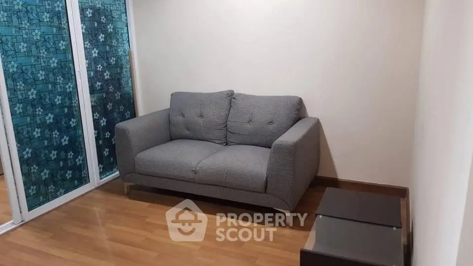 Cozy living room with modern gray sofa and wooden flooring, perfect for relaxation.