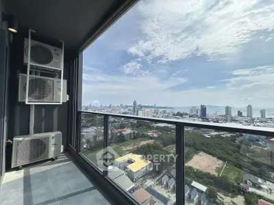 Stunning high-rise balcony view with cityscape and ocean horizon.