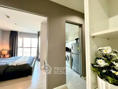 Modern apartment with bedroom and kitchen featuring washing machine and fridge, bright and airy design.