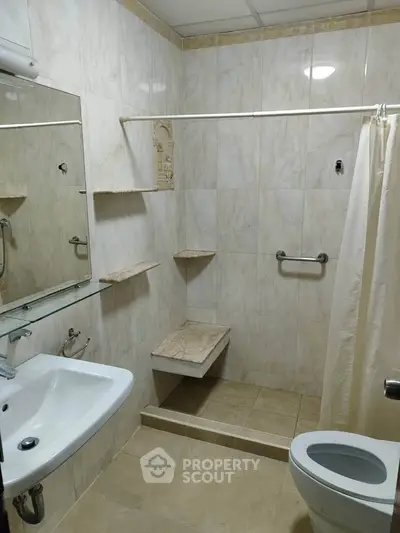 Spacious bathroom with modern fixtures and a convenient shower bench.