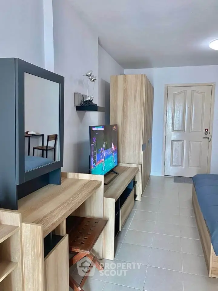 Modern living room with sleek furniture and wall-mounted TV, perfect for relaxation and entertainment.