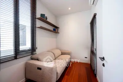 Cozy modern living room with sleek wooden floors and stylish blinds.