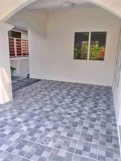 Spacious tiled patio area with modern design and natural light, perfect for outdoor relaxation.