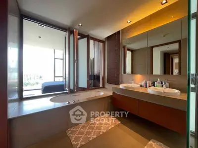 Luxurious bathroom with dual sinks and a bathtub, featuring modern design and ample natural light.