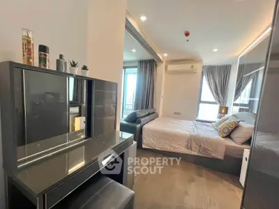 Modern bedroom with stylish decor and natural light, featuring a cozy bed and elegant vanity.