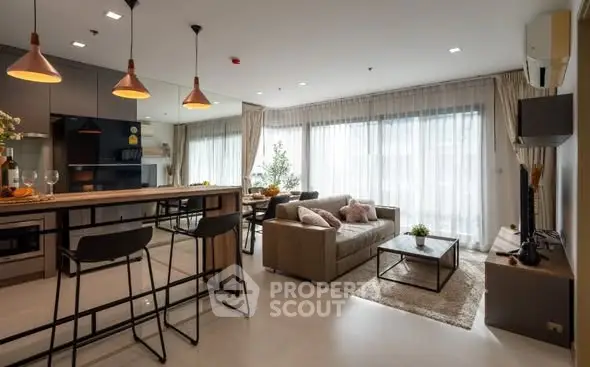 Modern open-plan living room with stylish kitchen and large windows.