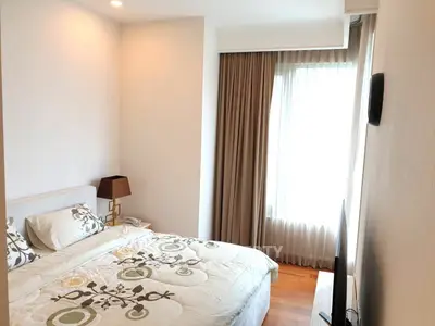 Cozy bedroom with elegant decor and natural light, featuring a comfortable bed and stylish curtains.