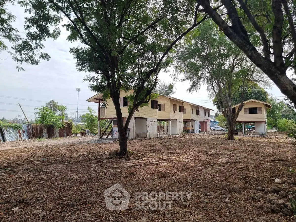 Spacious property with multiple buildings surrounded by trees, ideal for development.