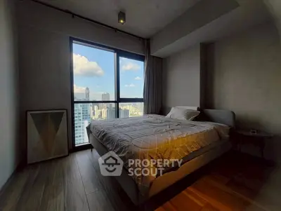 Modern bedroom with city view and stylish decor in high-rise apartment.