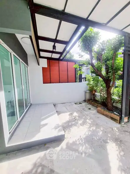 Charming outdoor patio with modern design and lush greenery, perfect for relaxation and entertaining.