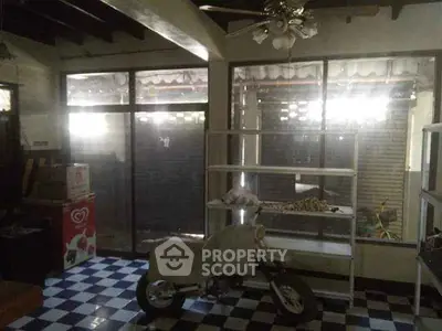 Spacious room with checkered floor, large windows, and ceiling fan, ideal for versatile use.