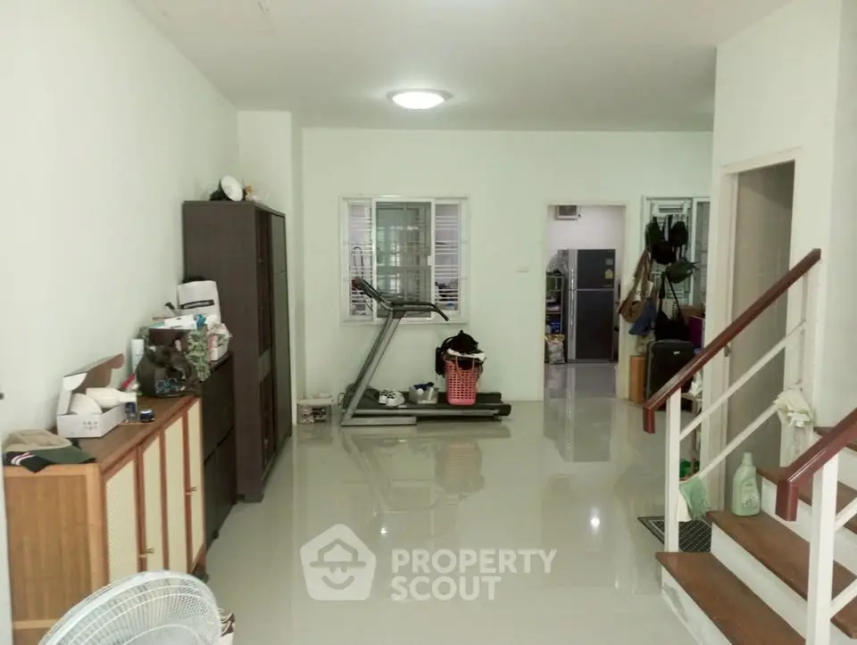 Spacious living area with treadmill and storage, ideal for fitness enthusiasts.