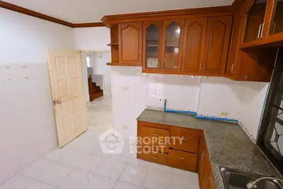 Spacious kitchen with wooden cabinets and granite countertops in a modern home.