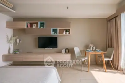 Modern living room with stylish furniture and natural light, featuring a wall-mounted TV and cozy dining area.