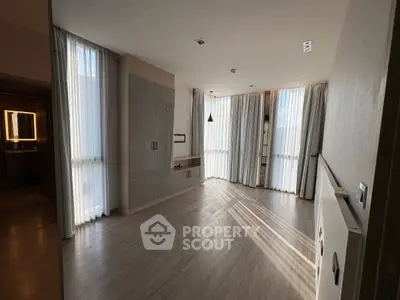 Spacious modern living room with large windows and elegant flooring