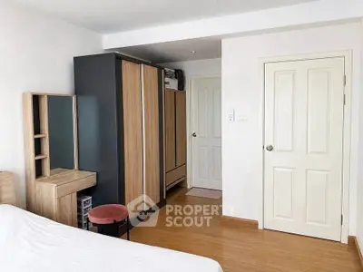 Cozy bedroom with modern wardrobe and wooden flooring, perfect for comfortable living.