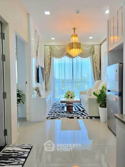 Luxurious living room with elegant chandelier and modern decor, featuring a stunning view through large windows.