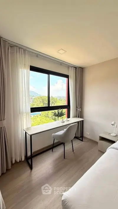 Bright bedroom with large window and study desk offering scenic views, perfect for work and relaxation.