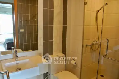 Modern bathroom with glass shower and sleek fixtures in a stylish apartment.